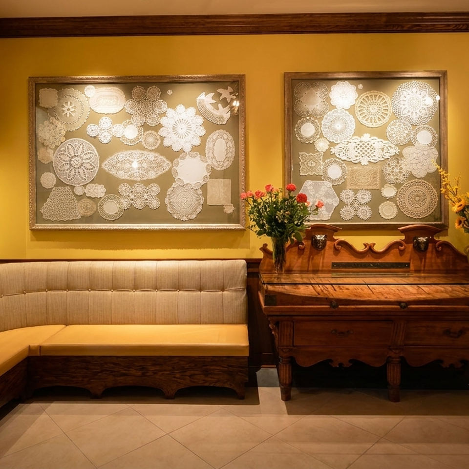 A cozy restaurant interior with yellow walls, a corner booth, and framed doily art.